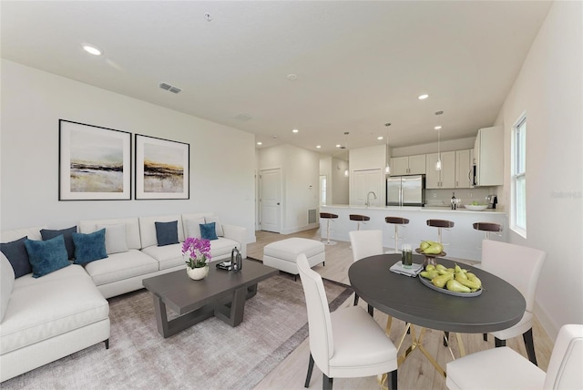 living room with sink and light hardwood / wood-style floors