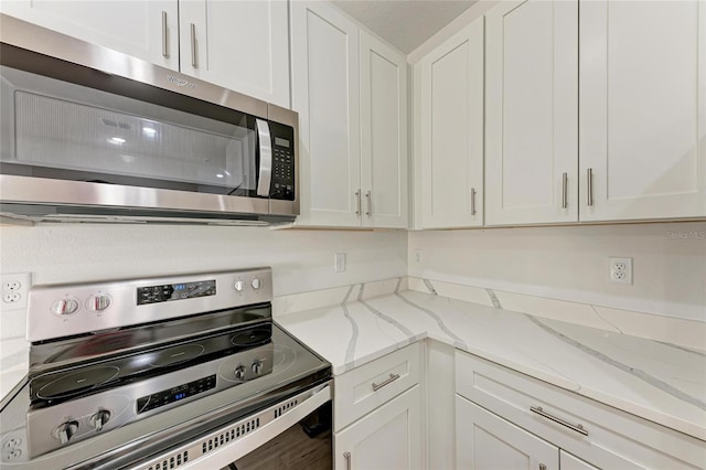 kitchen featuring white cabinetry, stainless steel appliances, and light stone countertops