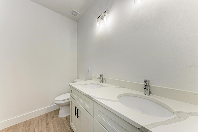 bathroom featuring vanity, wood-type flooring, and toilet