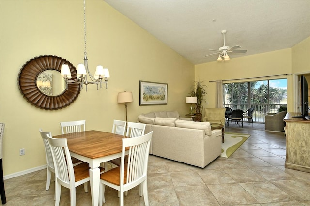 dining space featuring light tile patterned floors, ceiling fan with notable chandelier, and high vaulted ceiling