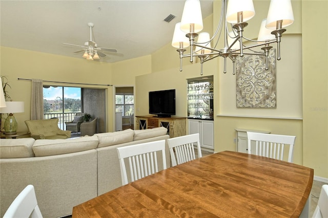 dining area featuring ceiling fan with notable chandelier