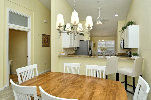 dining space featuring lofted ceiling and ceiling fan with notable chandelier