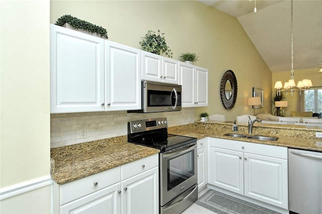 kitchen featuring pendant lighting, stainless steel appliances, sink, and white cabinets