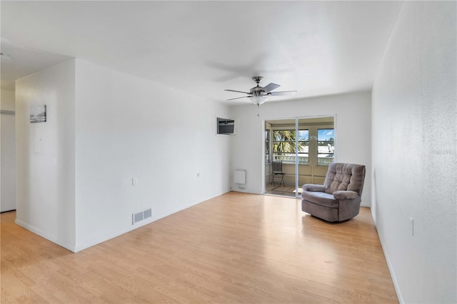 unfurnished room featuring light hardwood / wood-style flooring, an AC wall unit, and ceiling fan