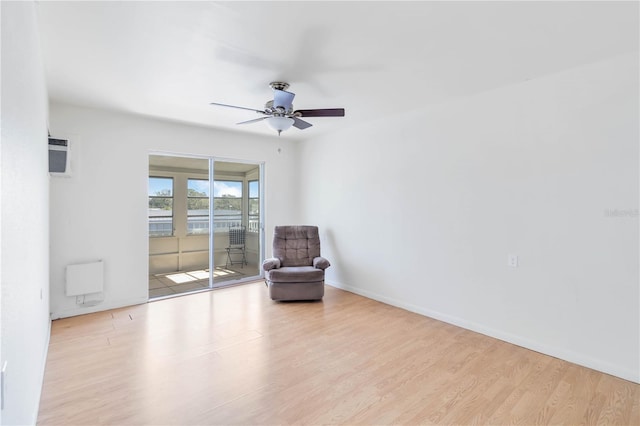 unfurnished room with a wall mounted air conditioner, light hardwood / wood-style floors, and ceiling fan