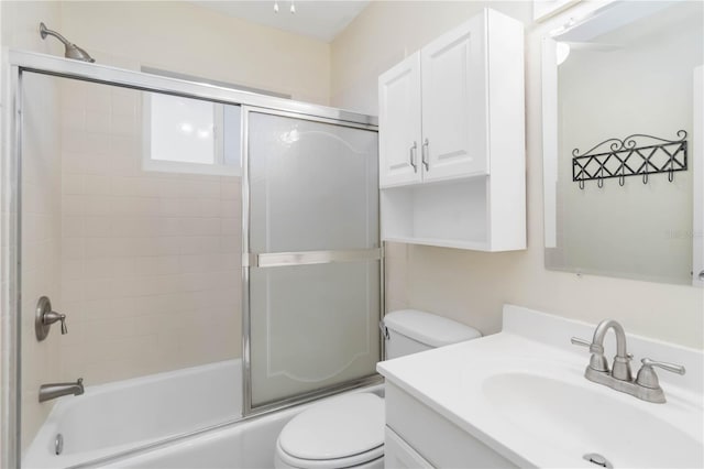 full bathroom featuring vanity, shower / bath combination with glass door, and toilet