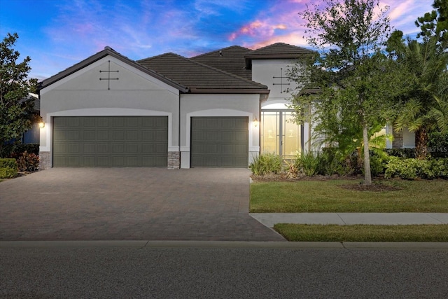 view of front of home featuring a garage and a lawn