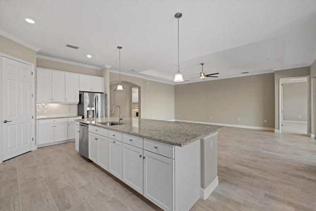 kitchen with white cabinetry, appliances with stainless steel finishes, a kitchen island with sink, and sink