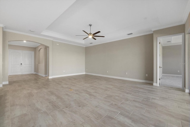 unfurnished room featuring a tray ceiling, light hardwood / wood-style flooring, ornamental molding, and ceiling fan