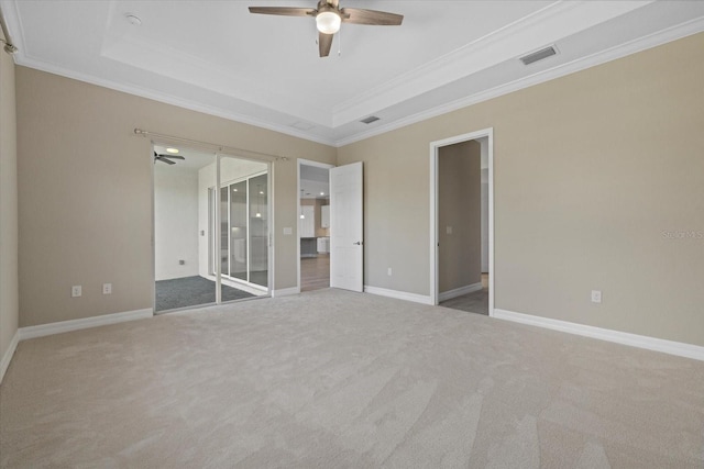 unfurnished bedroom with ornamental molding, carpet flooring, and a raised ceiling