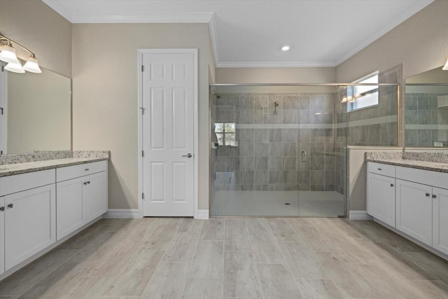 bathroom with vanity, an enclosed shower, and ornamental molding