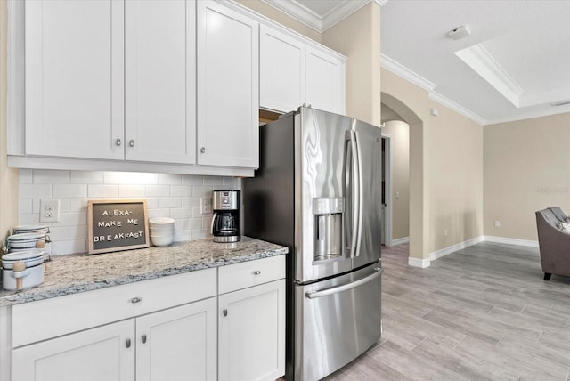 12029 Perennial Pl, Lakewood Ranch, FL 34211 - kitchen featuring stainless steel fridge, arched walkways, ornamental molding, decorative backsplash, and white cabinetry