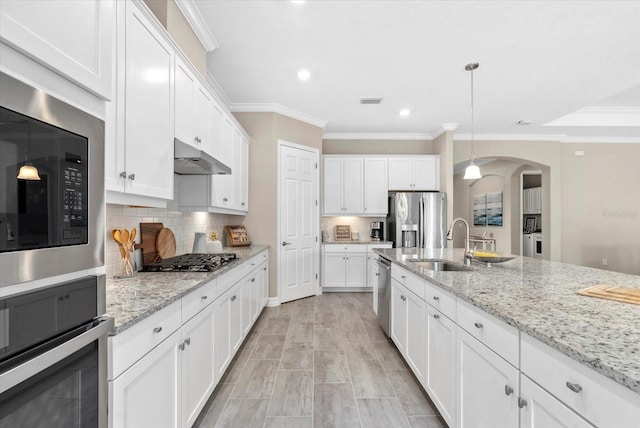 12029 Perennial Pl, Lakewood Ranch, FL 34211 - kitchen with appliances with stainless steel finishes, arched walkways, a sink, crown molding, and white cabinetry