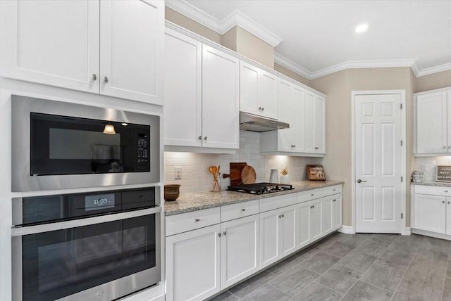 12029 Perennial Pl, Lakewood Ranch, FL 34211 - kitchen featuring stainless steel oven, built in microwave, under cabinet range hood, white cabinetry, and ornamental molding