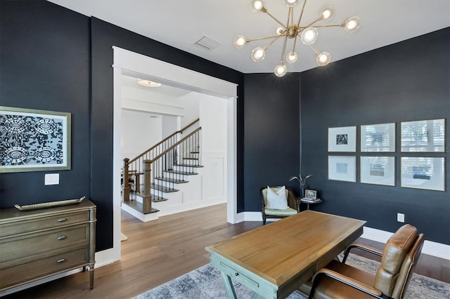 office area with visible vents, a notable chandelier, baseboards, and wood finished floors