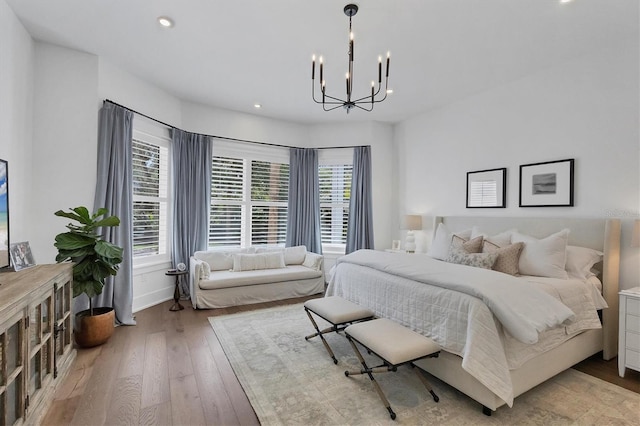 bedroom with recessed lighting, baseboards, light wood finished floors, and an inviting chandelier