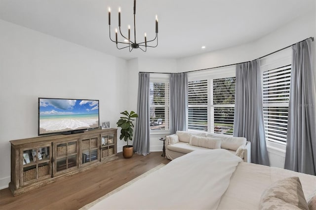 bedroom featuring an inviting chandelier, wood finished floors, and recessed lighting