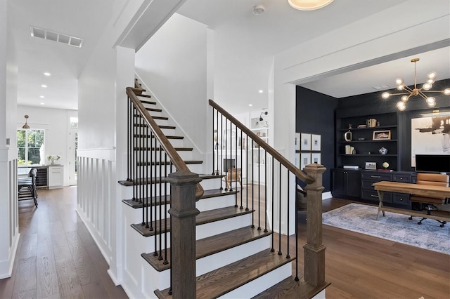 stairway featuring built in features, beverage cooler, visible vents, and wood finished floors