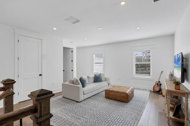 living room featuring a wealth of natural light, wood finished floors, visible vents, and recessed lighting