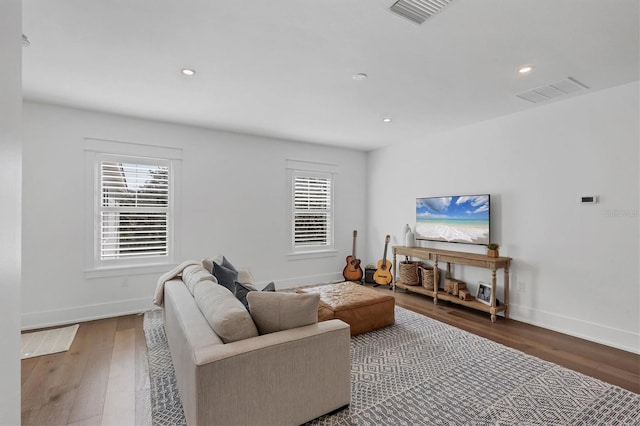 living room featuring visible vents, plenty of natural light, and wood finished floors