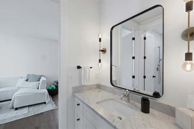 ensuite bathroom featuring wood finished floors, a shower, connected bathroom, and vanity