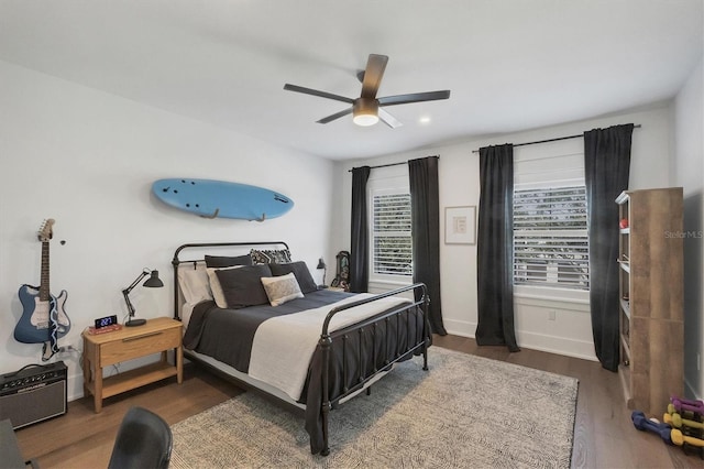 bedroom with dark wood-style floors, ceiling fan, and baseboards