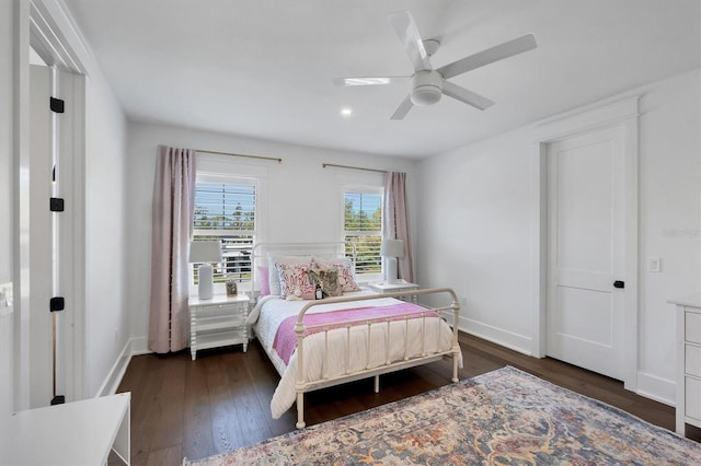 bedroom featuring a ceiling fan, baseboards, and dark wood-type flooring