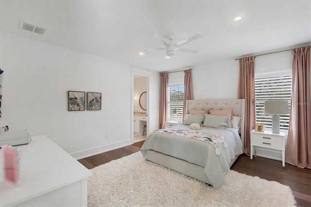 bedroom featuring dark wood-style floors, visible vents, ensuite bathroom, a ceiling fan, and baseboards