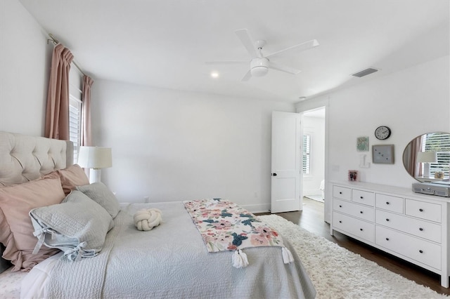 bedroom featuring dark wood-style floors, ceiling fan, multiple windows, and visible vents