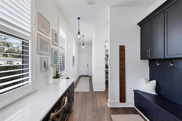 mudroom featuring dark wood-type flooring, visible vents, and baseboards