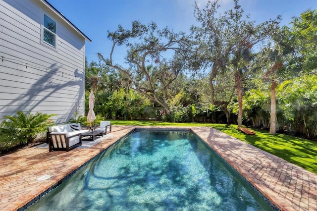 view of swimming pool featuring a patio area, fence, an outdoor living space, and a lawn