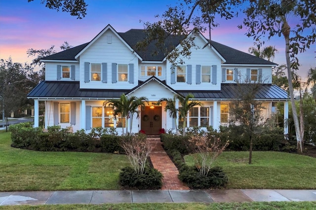 view of front of home featuring a standing seam roof, metal roof, and a yard