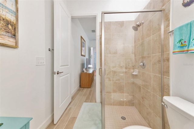 bathroom with toilet and a shower with shower door