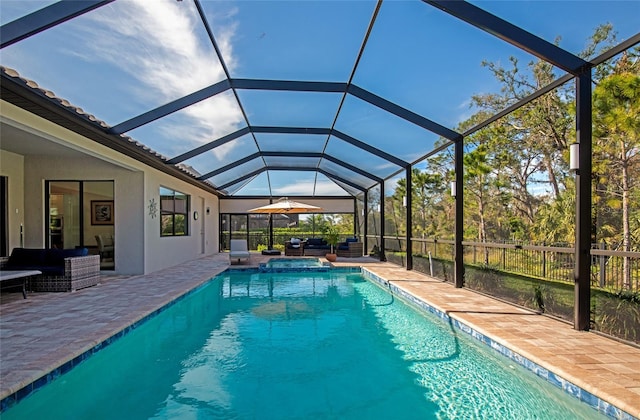 view of swimming pool featuring an outdoor living space, a patio area, and glass enclosure