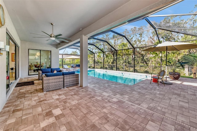 view of pool with a patio, an outdoor hangout area, and glass enclosure