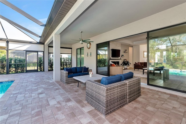 view of patio with outdoor lounge area, ceiling fan, and glass enclosure