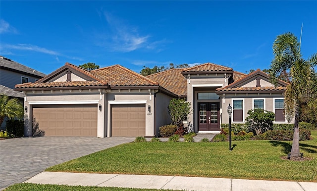 mediterranean / spanish-style home featuring a garage, a front lawn, and french doors