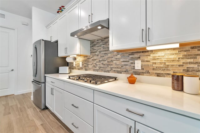 kitchen featuring white cabinetry, appliances with stainless steel finishes, light hardwood / wood-style flooring, and decorative backsplash