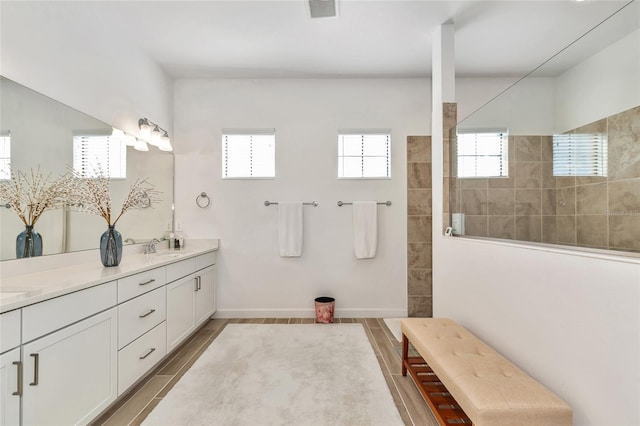 bathroom with vanity and tiled shower