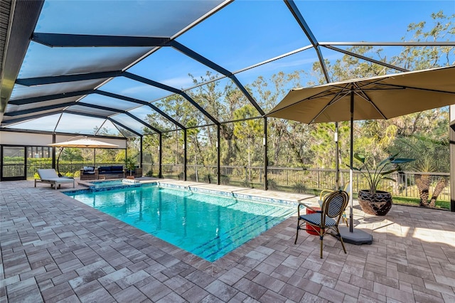 view of pool featuring an in ground hot tub, a patio, and glass enclosure