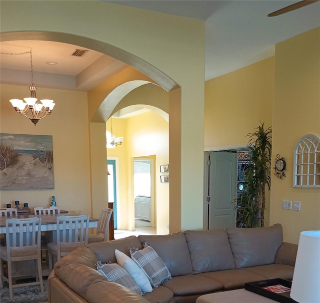 living room with a towering ceiling and an inviting chandelier