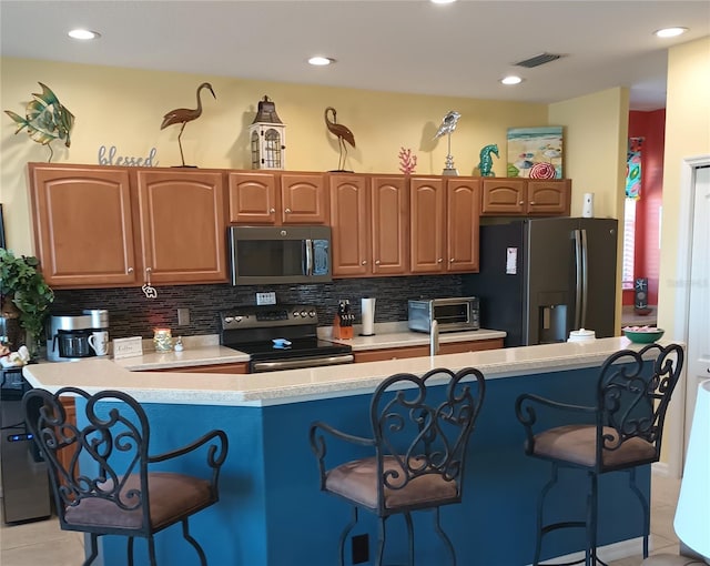 kitchen featuring decorative backsplash, stainless steel appliances, and a breakfast bar