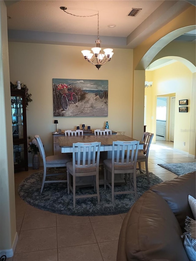 dining space with tile patterned flooring and a notable chandelier