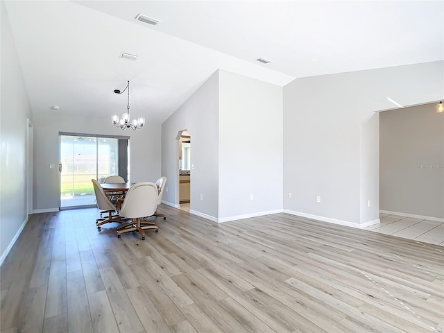 unfurnished dining area featuring lofted ceiling, a notable chandelier, and light wood-type flooring