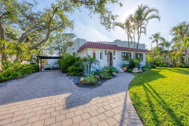 mediterranean / spanish-style home featuring a carport and a front yard