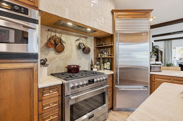 kitchen featuring backsplash, light hardwood / wood-style floors, and high quality appliances