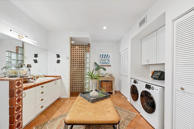 washroom with independent washer and dryer, sink, and light tile patterned floors