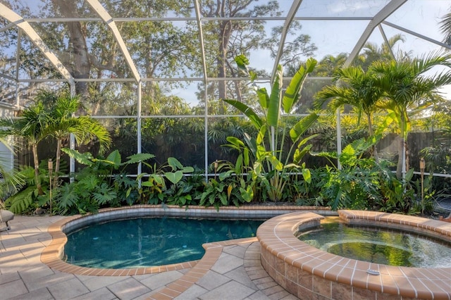 view of swimming pool with a lanai, a patio, and an in ground hot tub