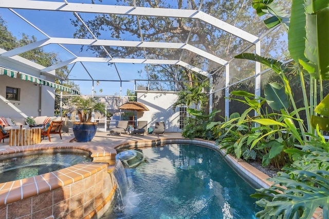 view of pool with an in ground hot tub, pool water feature, a lanai, and a patio area