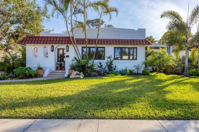 mediterranean / spanish home with a front lawn